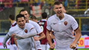 Roma's forward from Bosnia-Herzegovina Edin Dzeko (R) celebrates with Roma's forward from Argentina Juan Manuel Iturbe after scoring during the Italian Serie A football match Bologna vs AS Roma on November 21, 2015 at the Renato Dall'Ara stadium in Bologna. AFP PHOTO / GIUSEPPE CACACE (Photo credit should read GIUSEPPE CACACE/AFP/Getty Images)